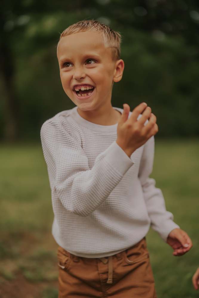 A boy mid-laugh in the open field
