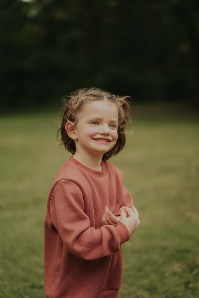 A little girl smiling in the afternoon light