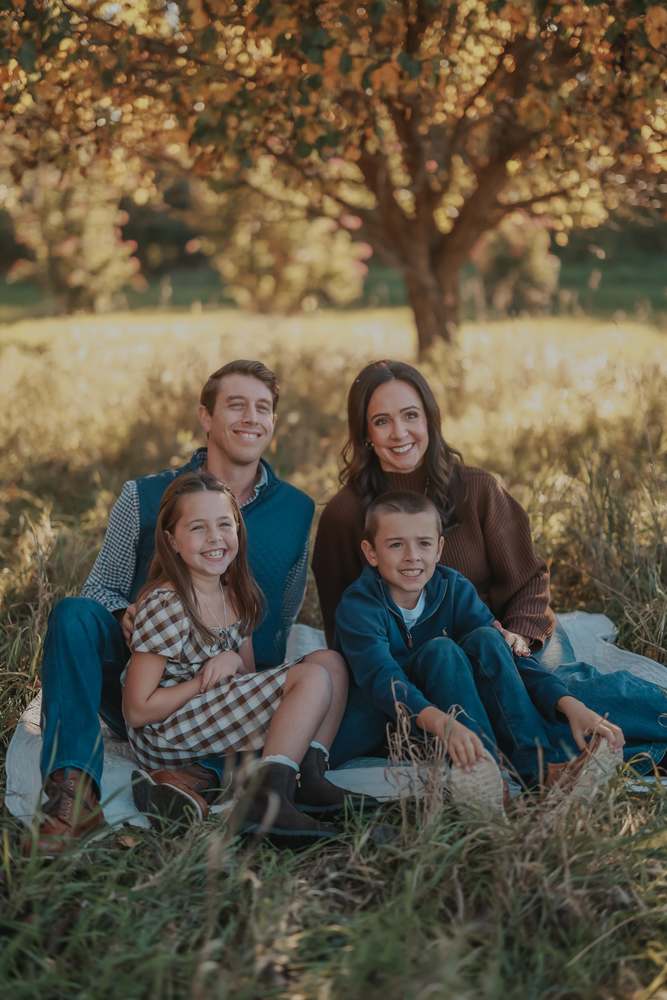 A family sitting together under the tree