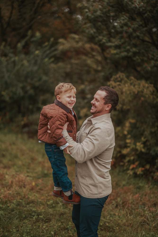 A father lifting his son up, both laughing