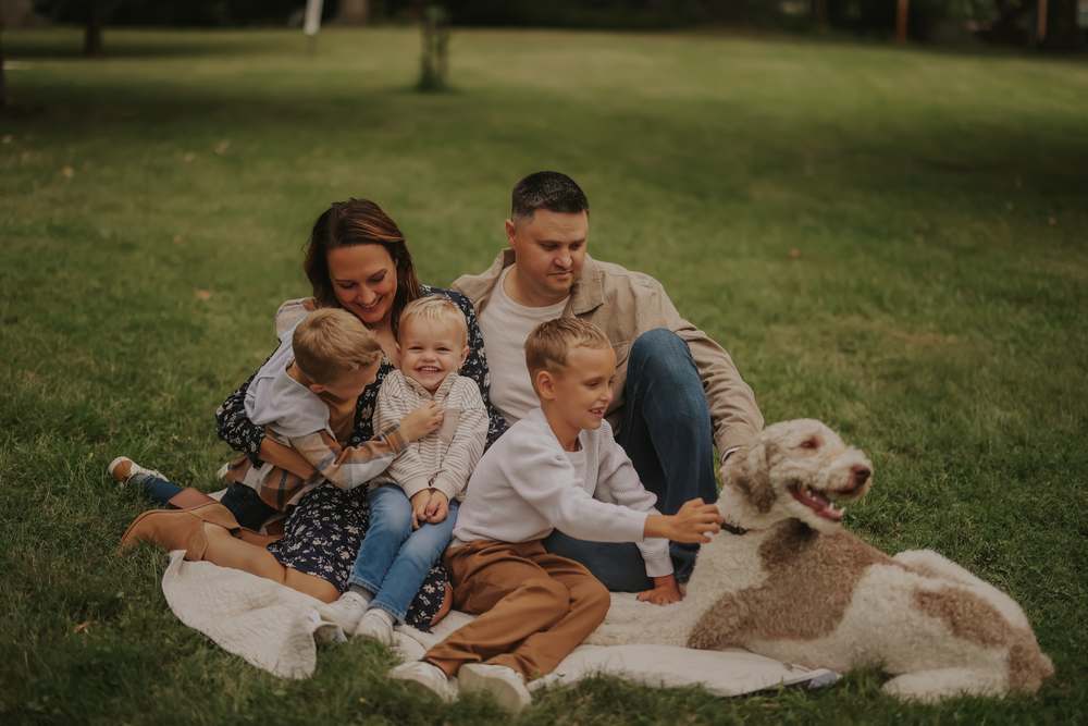 The whole family on the blanket with their dog
