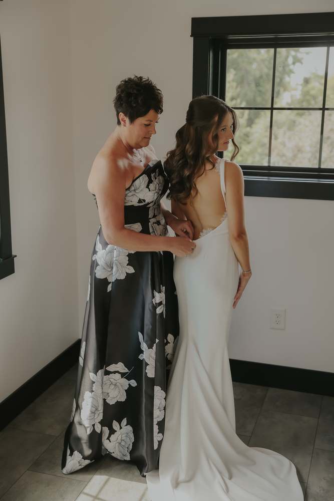 The bride's mother fastening the gown