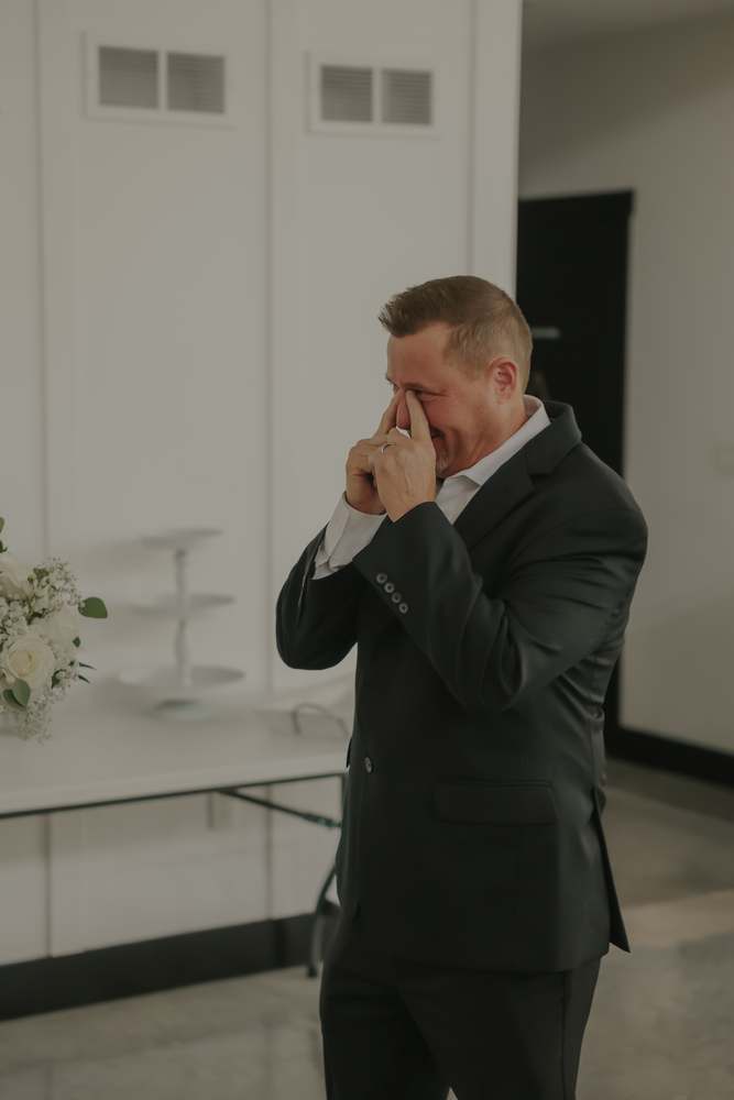 A father wiping away tears at the first look